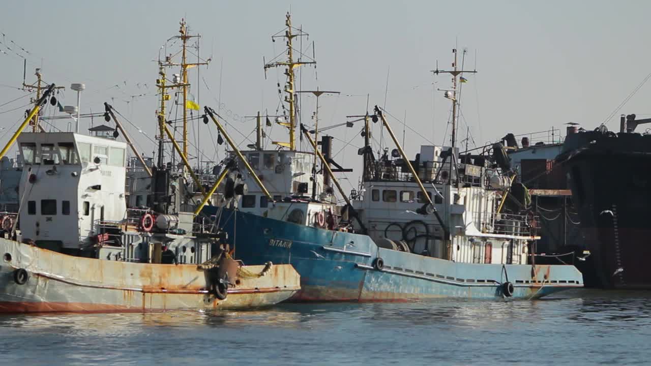 商业拖网渔船停靠在港口，海上渔业在行动。船员在甲板上工作，拖网，海上贸易蓬勃发展。航海船只准备公海捕捞，海产品经济。视频下载