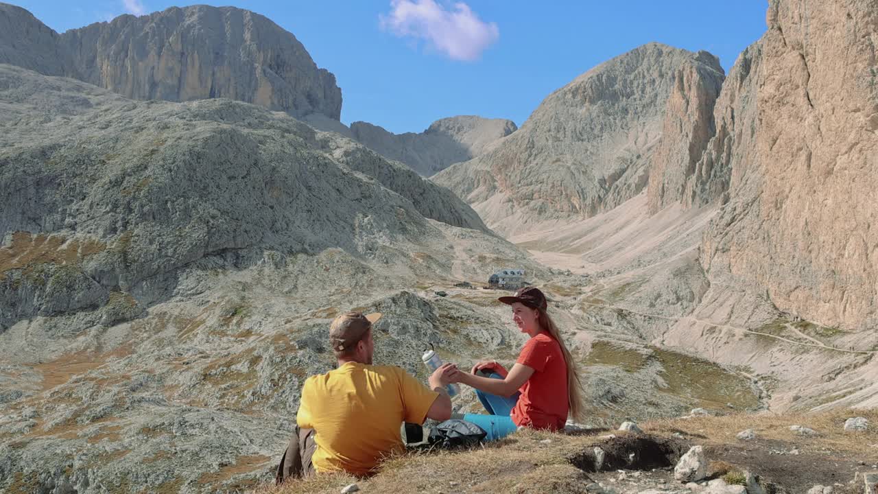 女人和男人在高空俯瞰壮观的山脉喝水视频下载