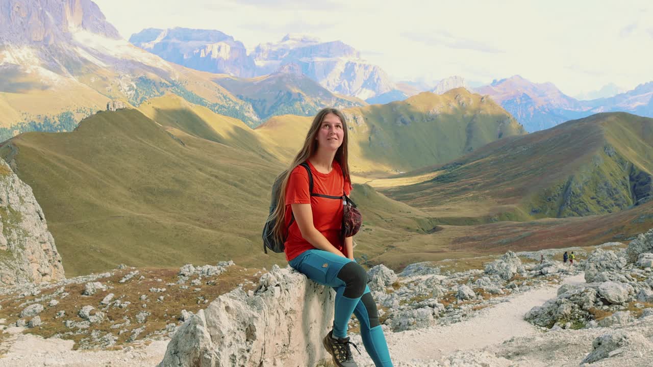 女徒步旅行者放松在白云石阿尔卑斯山与戏剧性的山景视频下载