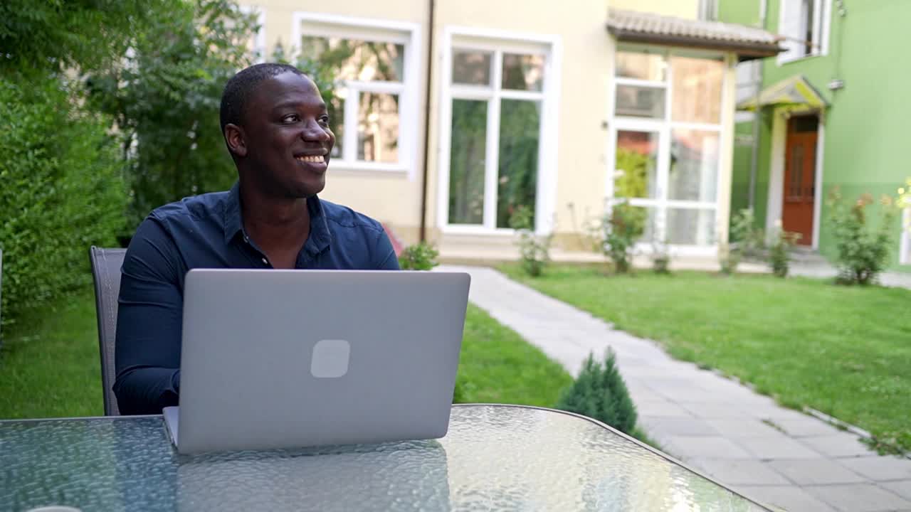 一个人在花园里用手提电脑上网视频下载