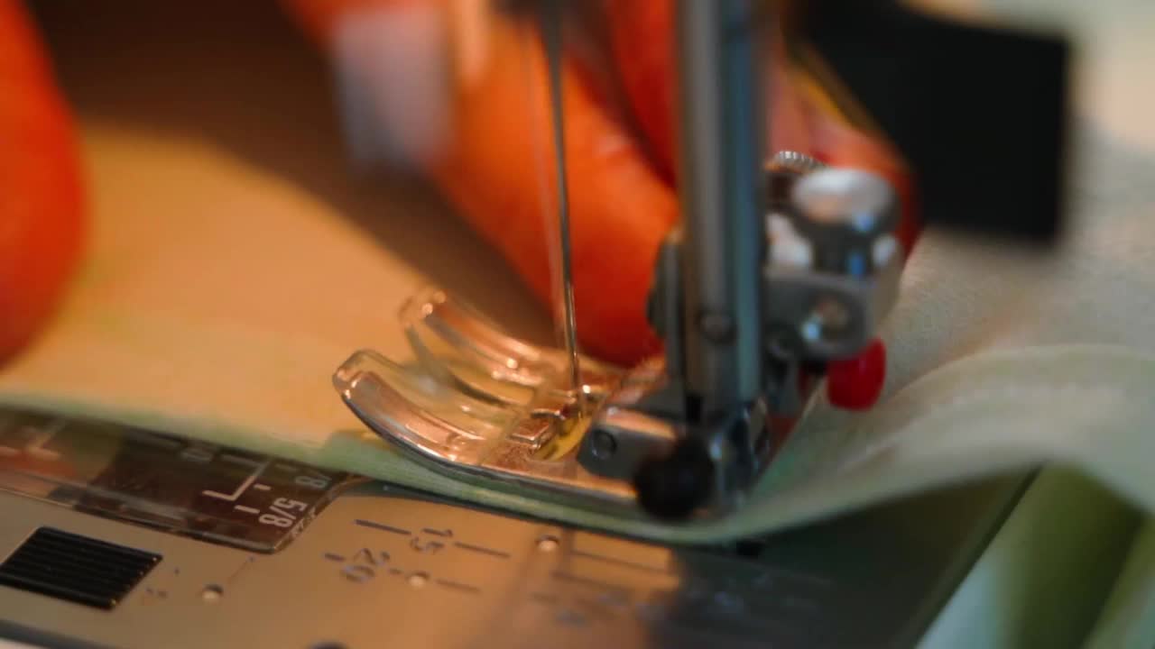 一个女人的手在缝纫机上缝东西，特写。热情的爱好氛围视频下载