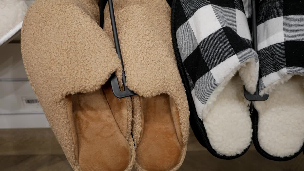 商店里的男士保暖拖鞋。为家庭收集新的温暖和柔软的鞋子。在大卖场的家居用品区购物。视频下载
