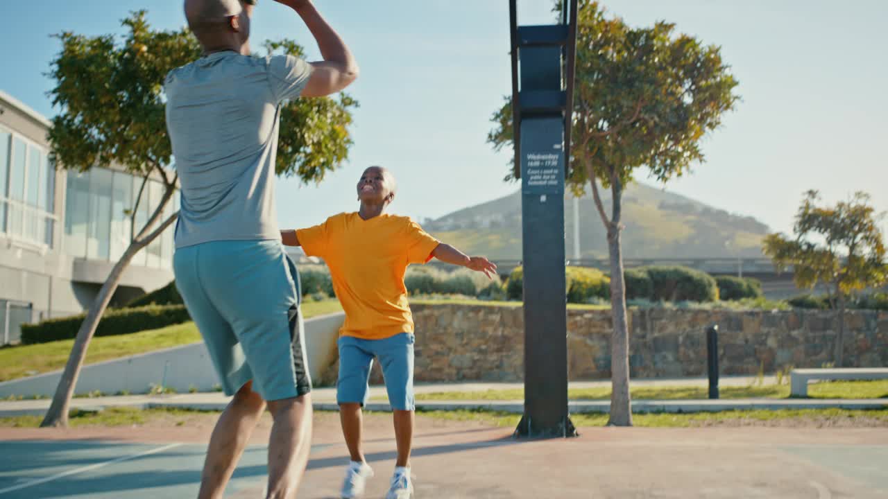 父亲，儿子和篮球场的家庭游戏，爸爸教男孩户外球类运动在社区公园锻炼和健身。黑人男子和孩子打篮球，增进感情视频下载