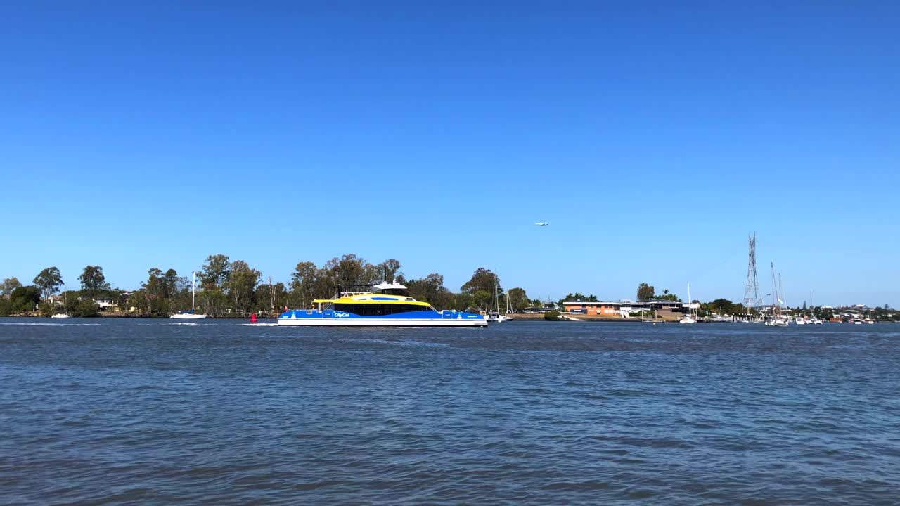 在一个蓝天夏日，公共交通系统中的双体船渡船在河上运送通勤者视频下载