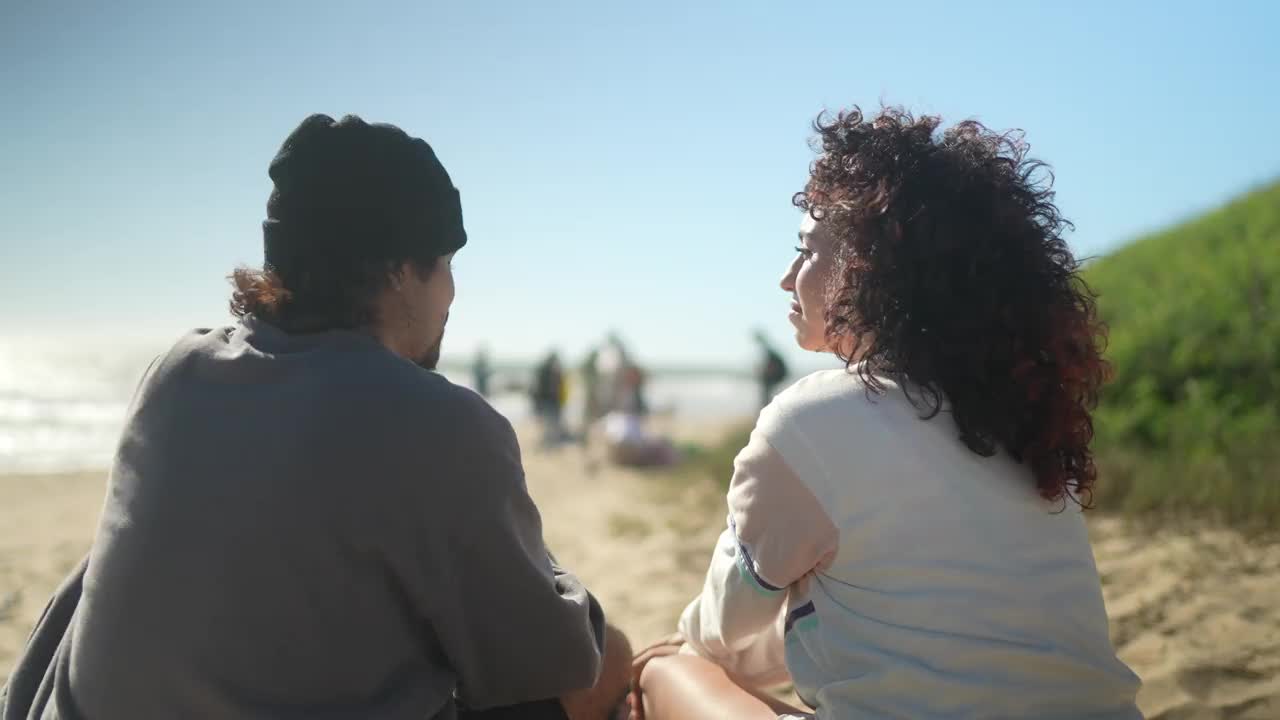 一对情侣在沙滩上聊天的照片视频下载