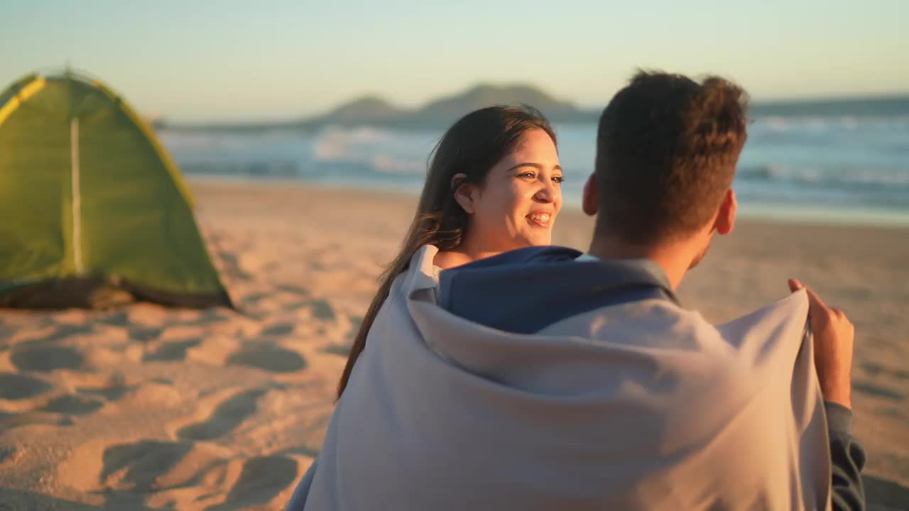 一对夫妇在海滩上聊天，拥抱，看着风景视频下载