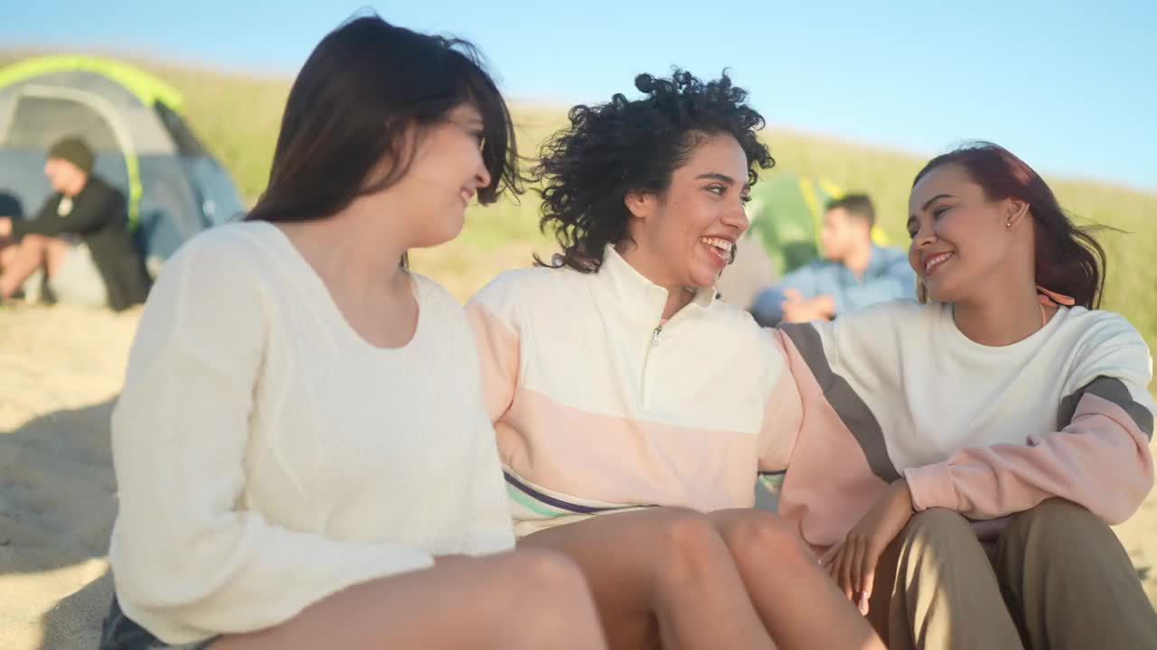 年轻女子在沙滩上与朋友聊天的照片视频素材