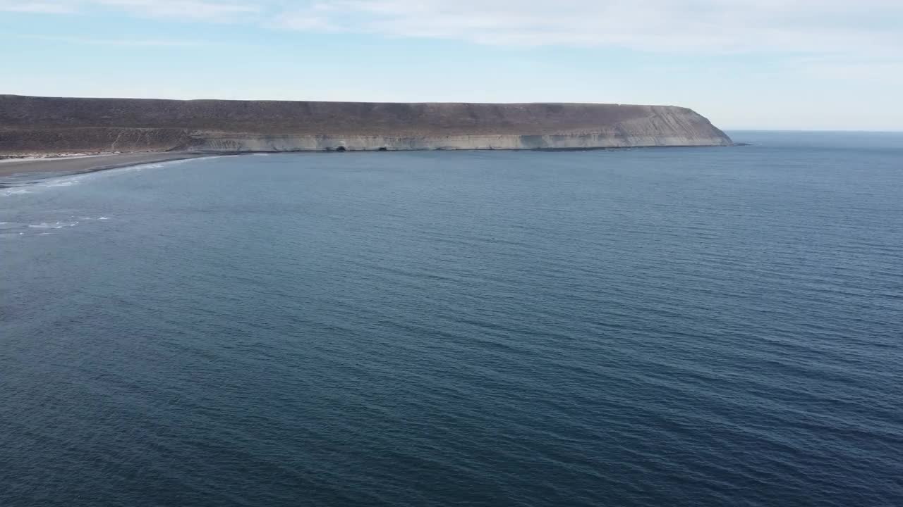 巴塔哥尼亚深蓝色的海岸线和高耸入海的浅棕色悬崖视频下载