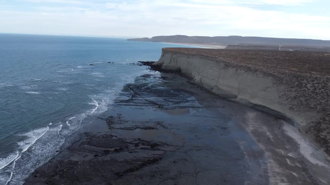 巴塔哥尼亚的海岸线小波浪和高浅棕色悬崖旁边的海滩视频下载