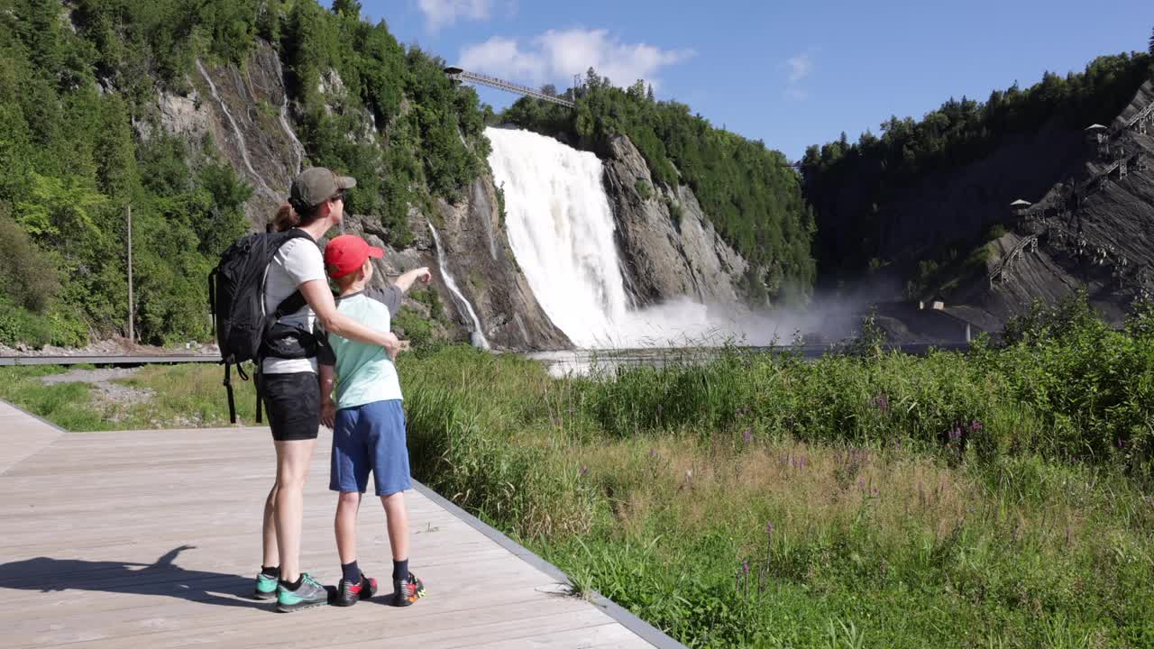 加拿大魁北克市，夏天，母亲和儿子走在蒙莫伦西瀑布的人行桥上视频下载