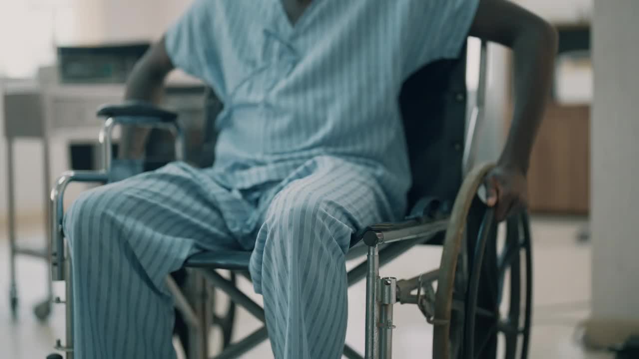 病人独自坐在候诊室的轮椅上，头痛不已。视频下载