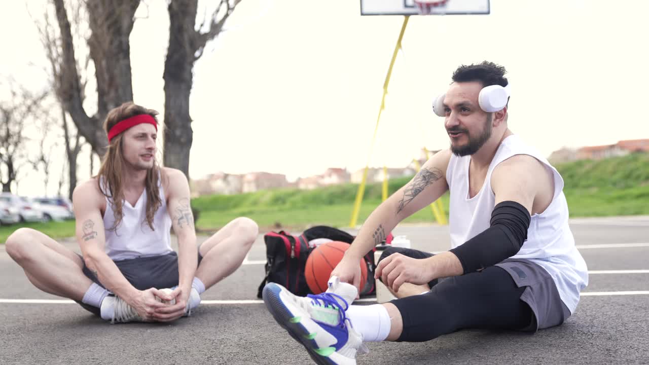 两个朋友坐在篮球场上聊天视频下载