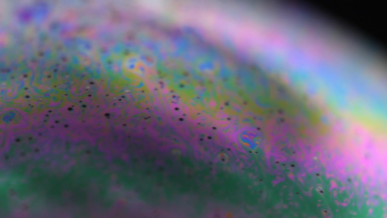 五彩缤纷的肥皂泡虹膜正在运动。现实的肥皂泡，眩光。极端泡沫宏观。视频下载