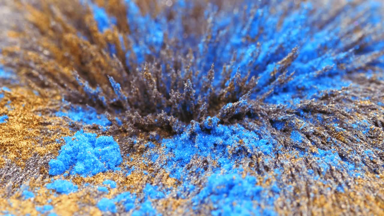 受磁场影响的黄色和蓝色金属粉尘、碎片、铁粉。抽象的背景。视频下载