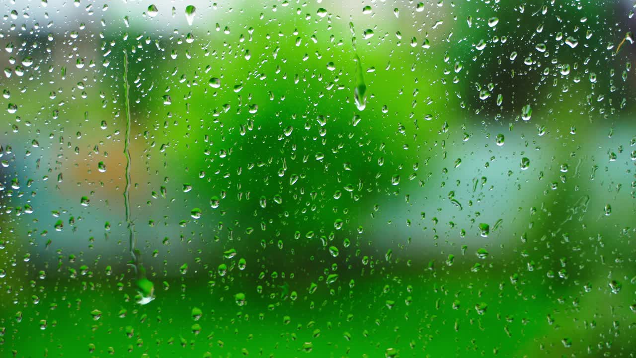 雨滴落在乡间别墅的窗户上，特写，背景模糊。雨的季节视频下载