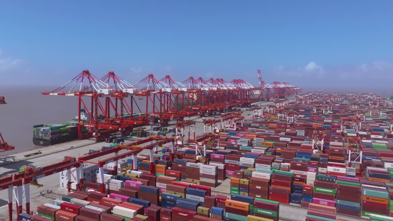 上海商港鸟瞰图，集装箱密集堆积，起重机繁忙装卸货船视频下载