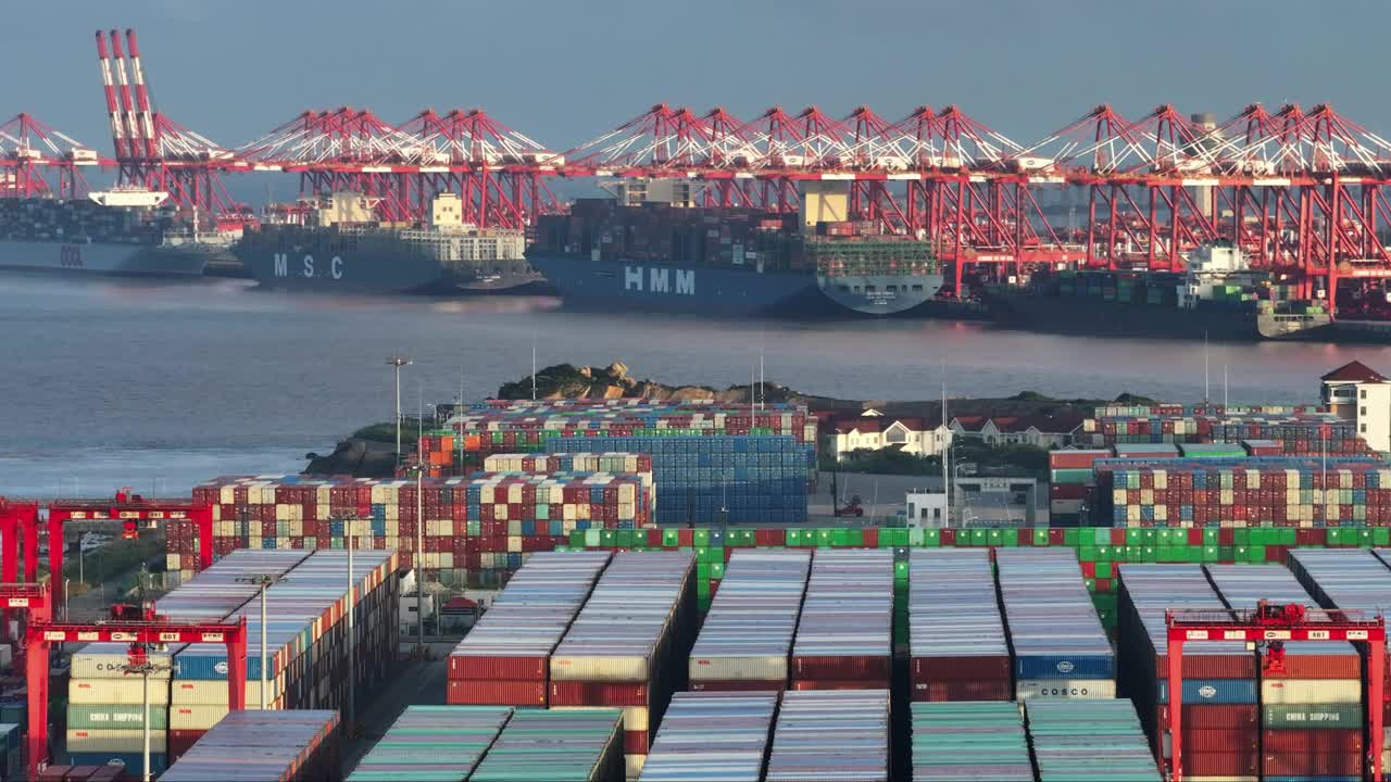 上海商港鸟瞰图，集装箱密集堆积，起重机繁忙装卸货船视频素材