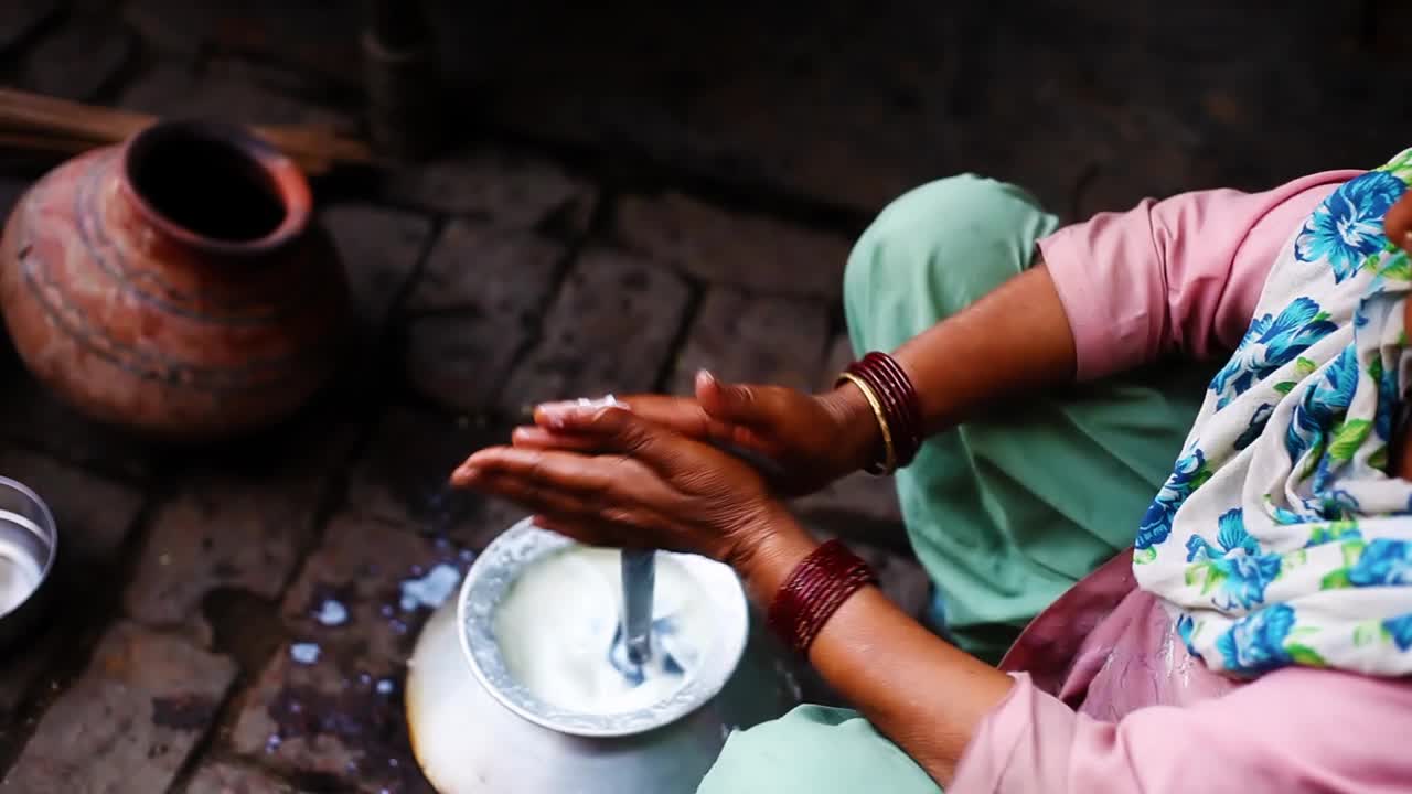 农村妇女从新鲜的酪乳中提取黄油!视频下载