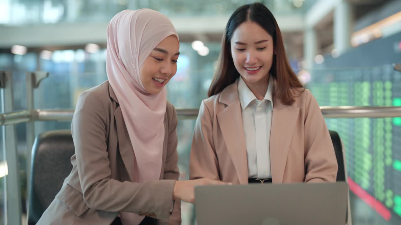 亚洲女商人在繁忙机场用笔记本电脑进行登机前工作视频下载