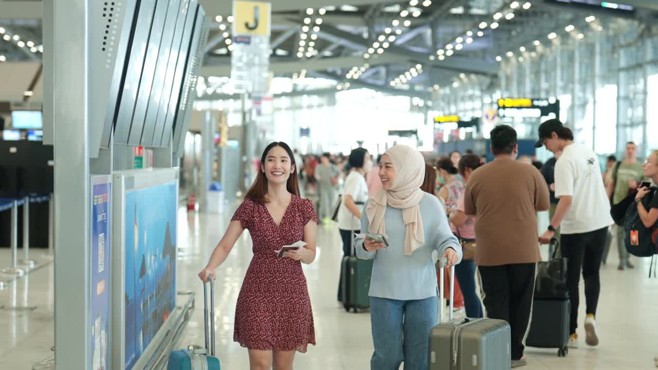 亚洲同事在繁忙的机场候机楼准备登机出差视频下载