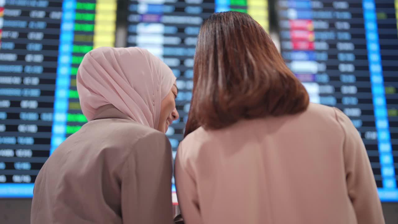 两名女商人在机场查看登机板上的航班信息视频下载