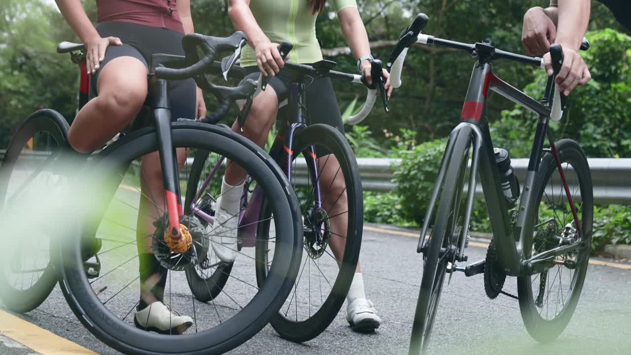年轻的亚洲自行车手在路边聊天视频下载
