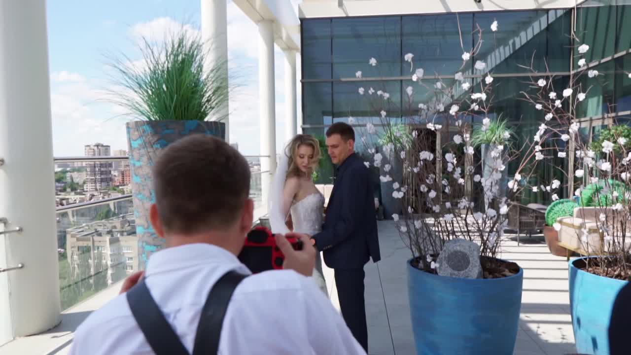 新娘和新郎在多层酒店露台上的后台照片视频素材