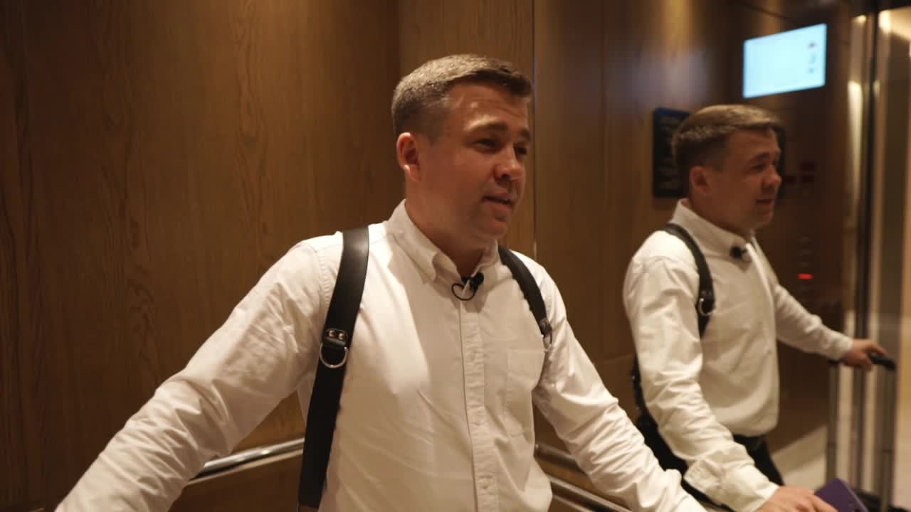 一名男摄影师搭乘电梯前往新娘的房间。视频下载