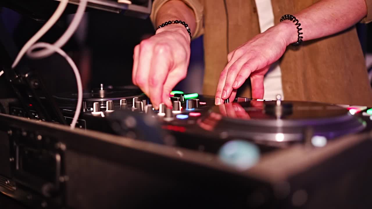 在派对上工作时，DJ手握音乐控制台。视频下载