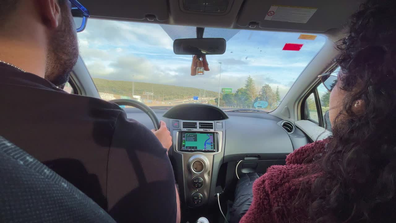 一对西班牙夫妇在一辆驶向西班牙加泰罗尼亚巴塞罗那的汽车里的特写视频下载