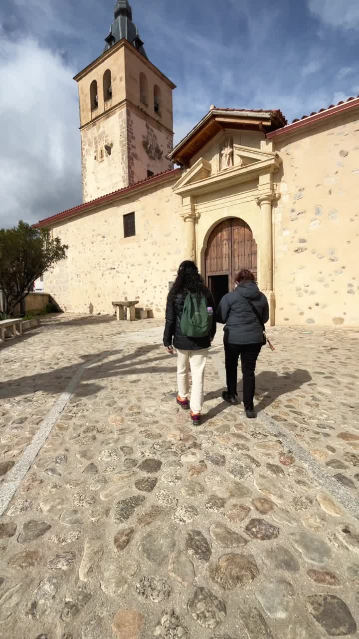 两名西班牙裔妇女正走向拉斯卡弗里亚镇天主教堂街。西班牙加泰罗尼亚视频下载