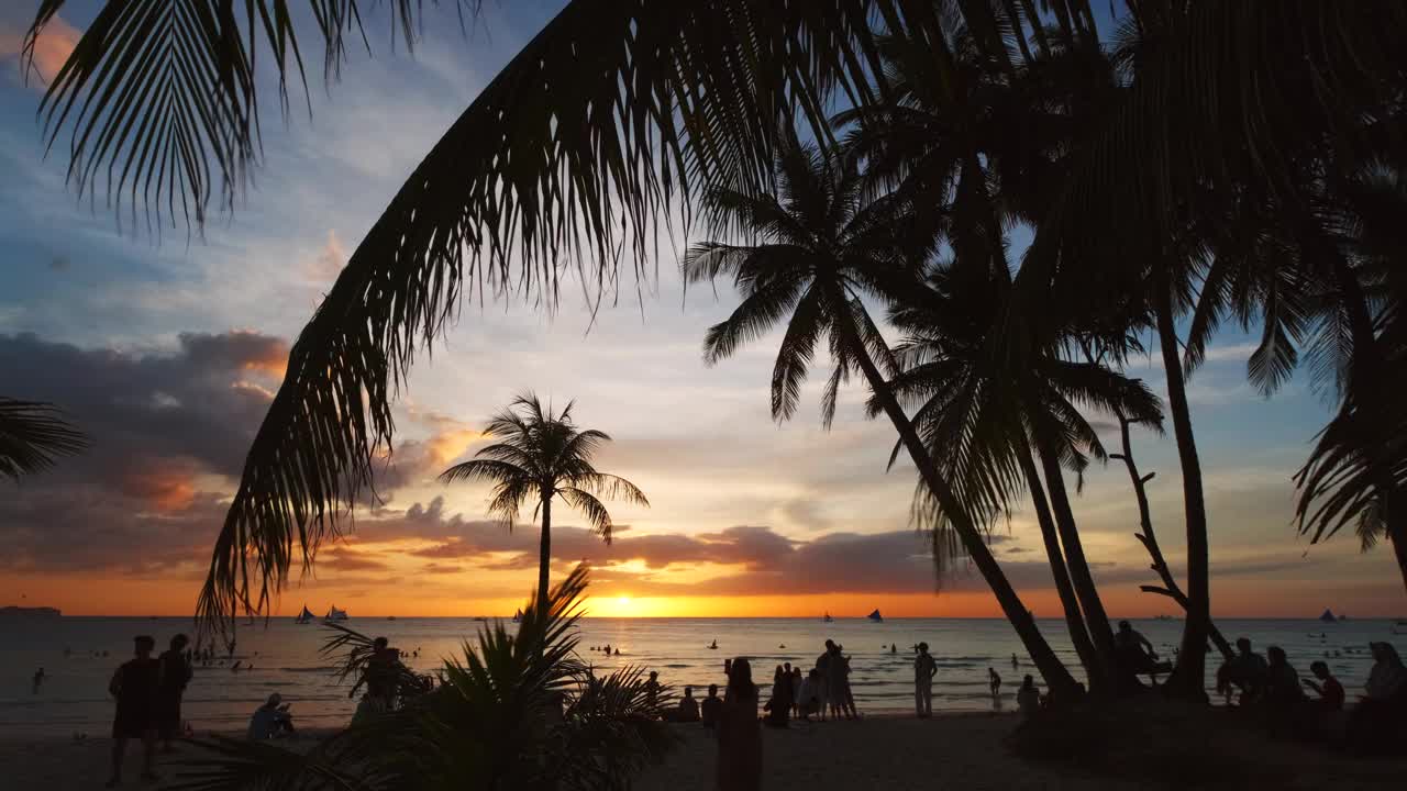 海滩上的日落，人们和棕榈树视频下载