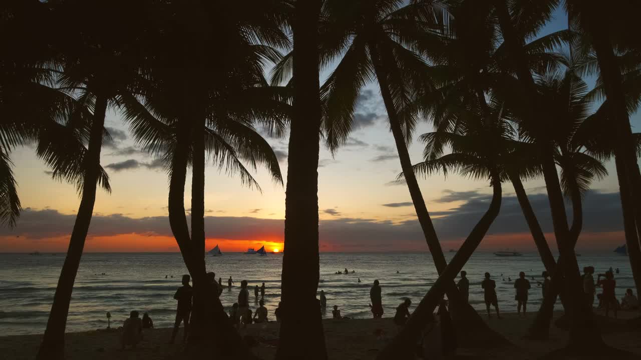 海滩上的日落，人们和棕榈树视频下载