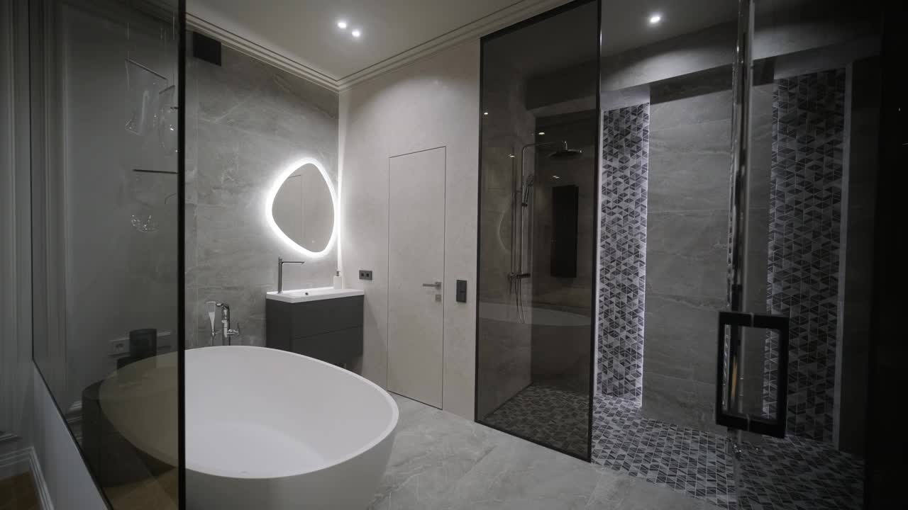 宽敞的浴室设计设有一个圆滑的独立浴缸，照明镜子，和一个步入式淋浴与详细的瓷砖工作视频下载
