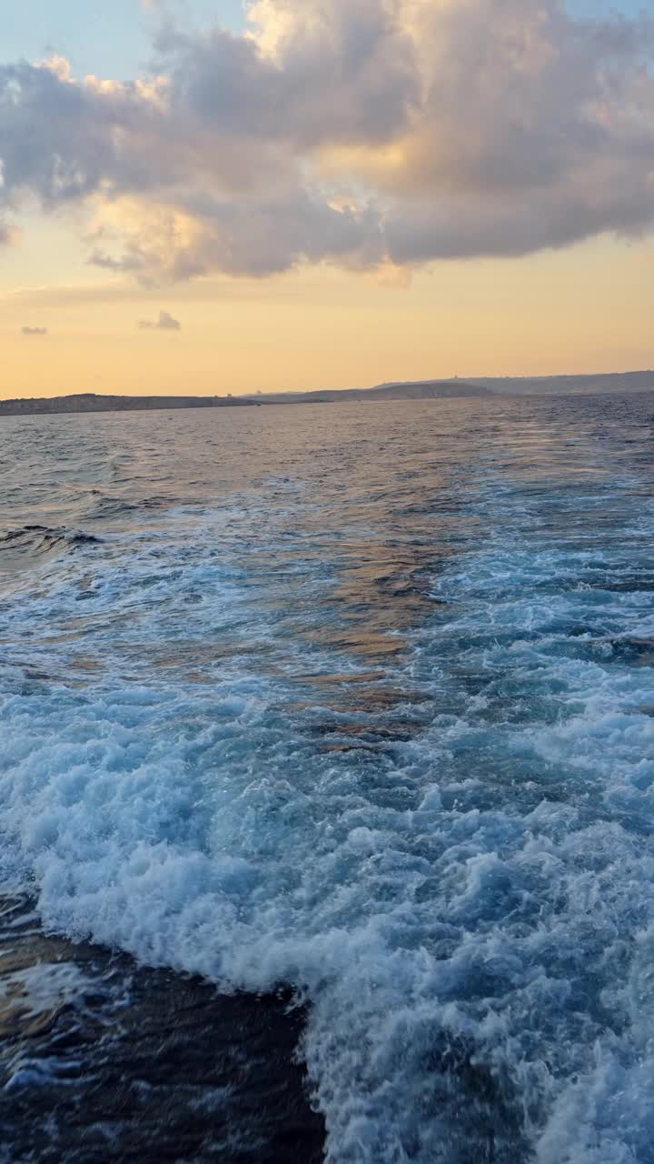 日落时分，马耳他移动船只上的海水上的泡沫痕迹视频下载