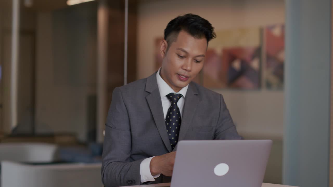 成功的亚洲商人使用笔记本电脑视频下载
