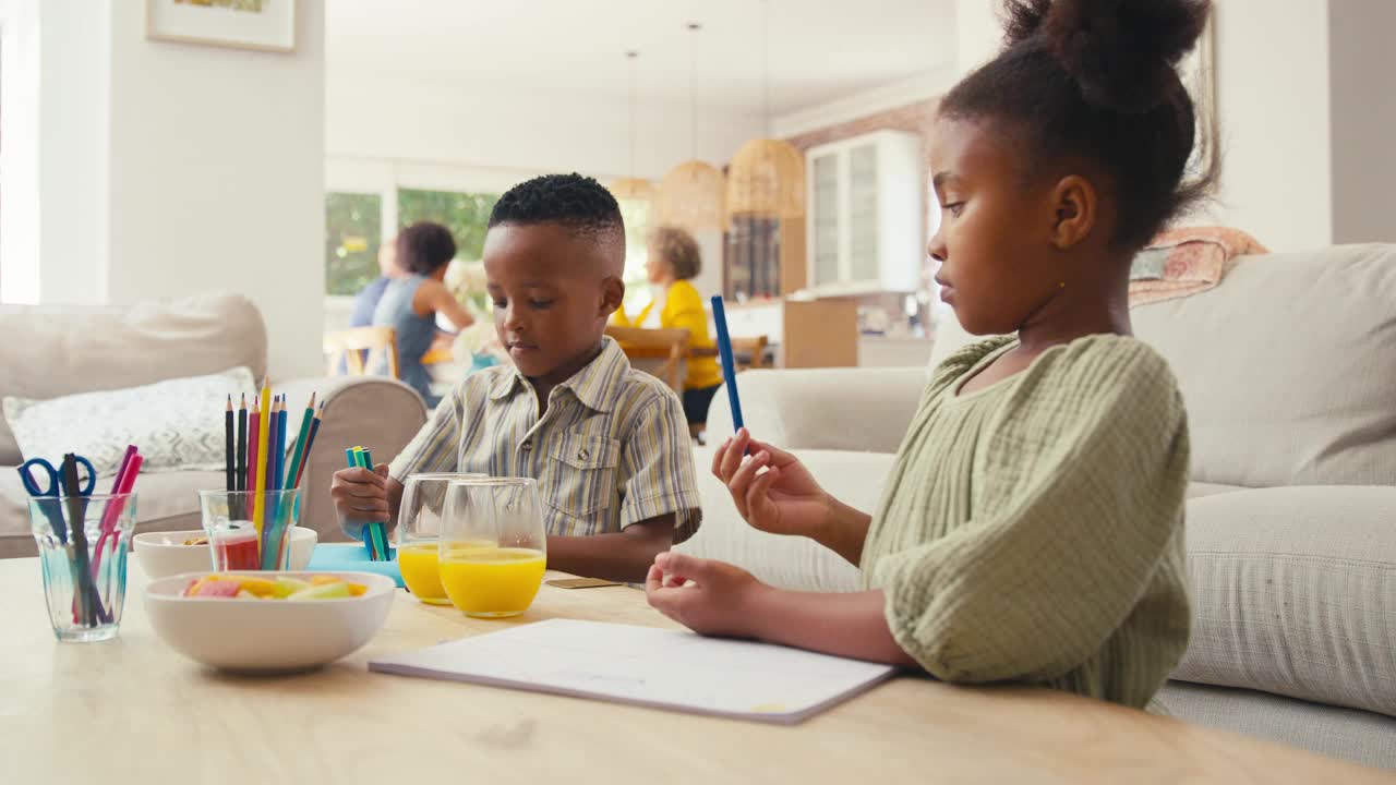 孙子们坐在家里的桌子旁画画，背景是几代同堂的家庭视频下载