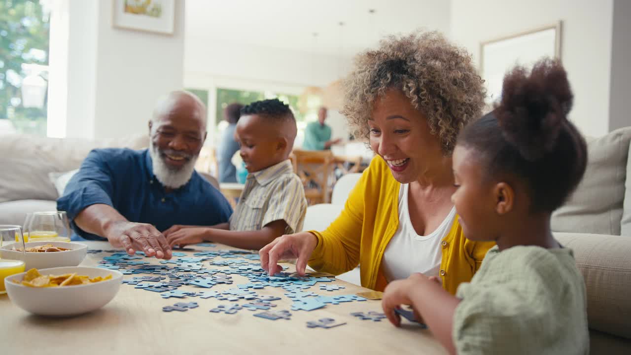 祖父母和孙子在家里玩拼图游戏，背后有父母视频下载