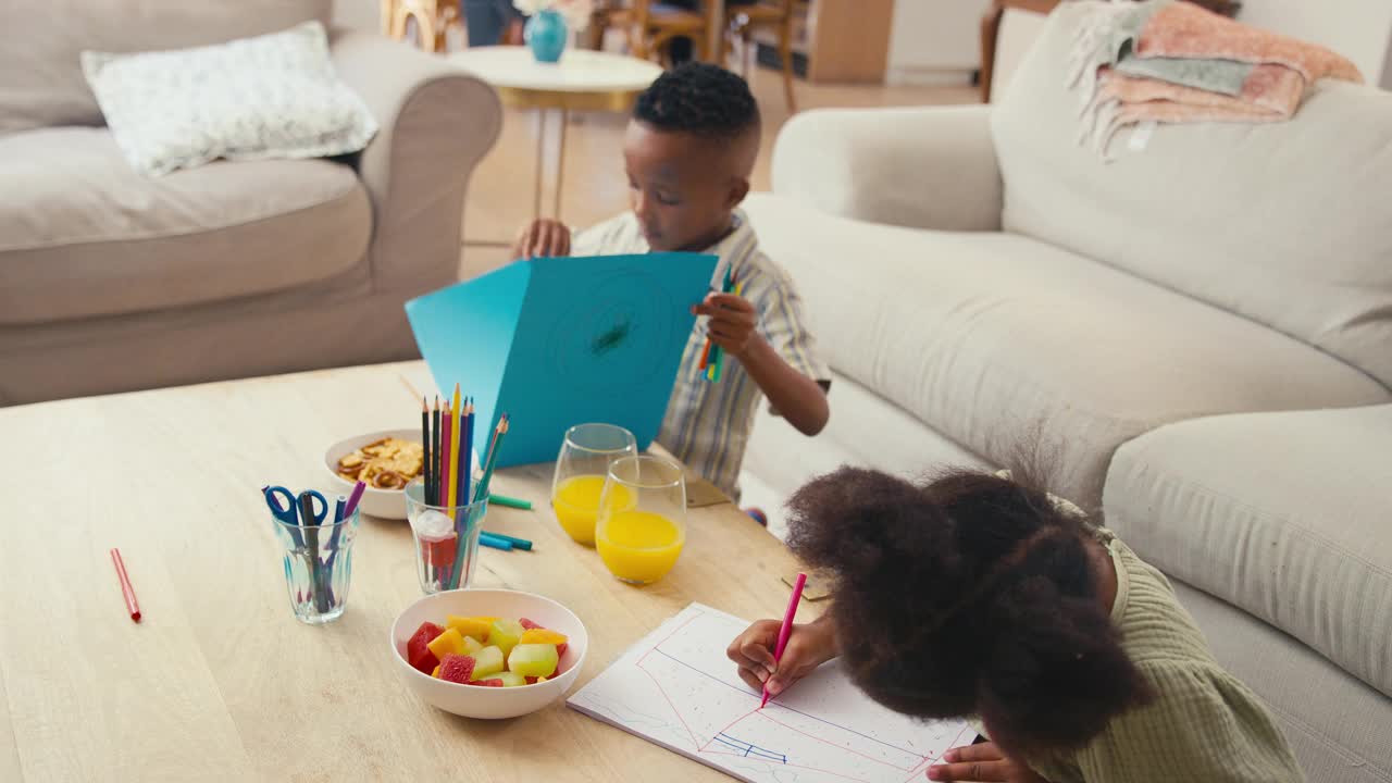 孙子们坐在家里的桌子旁画画，背景是几代同堂的家庭视频下载