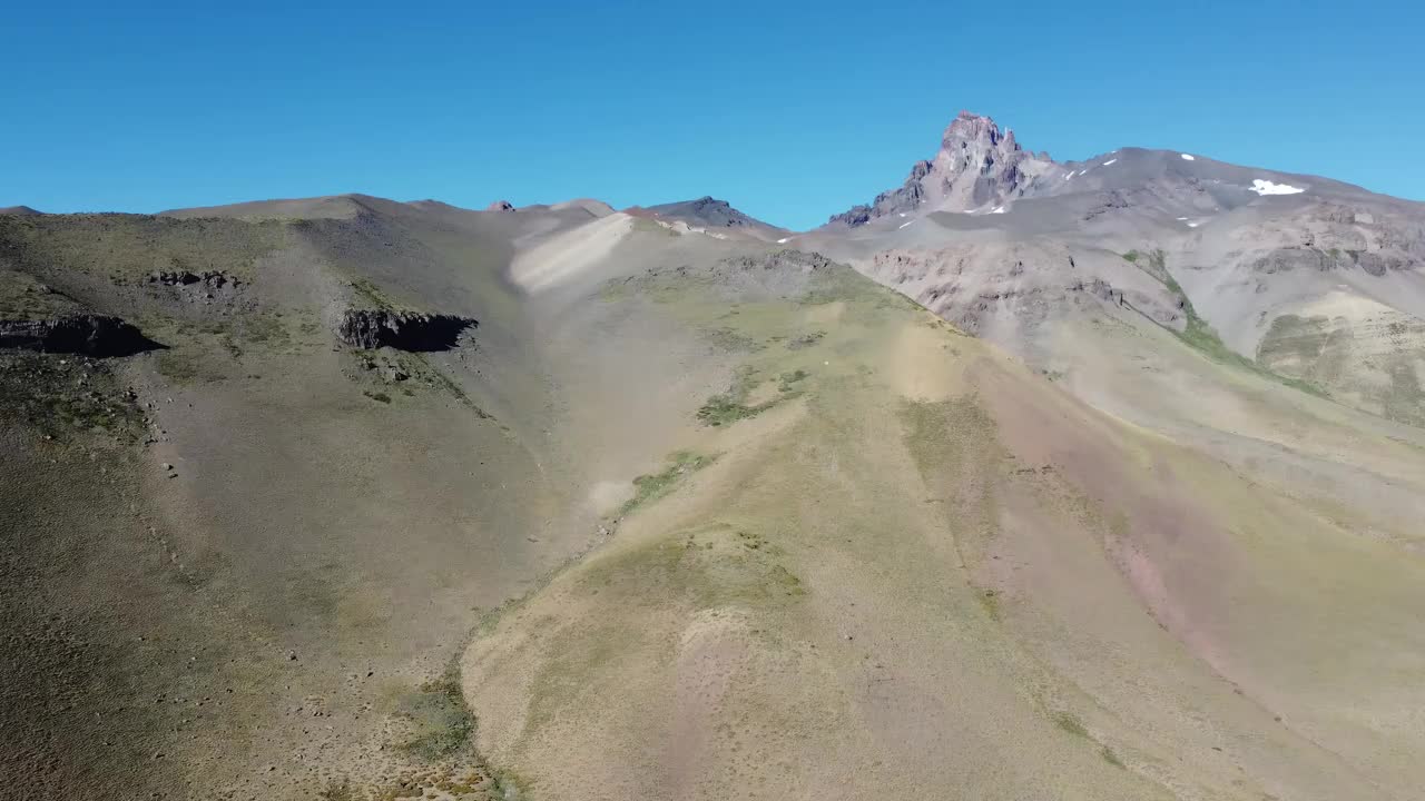 摄像机在安第斯山脉的山峰上平移，山峰上点缀着雪花视频下载