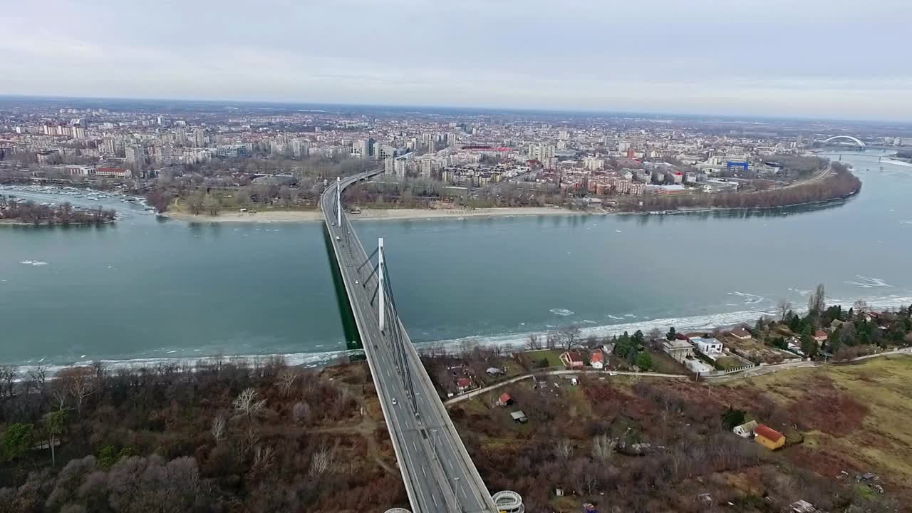 多云天，塞尔维亚诺维萨德，无人机在多瑙河上的桥梁上飞行视频下载
