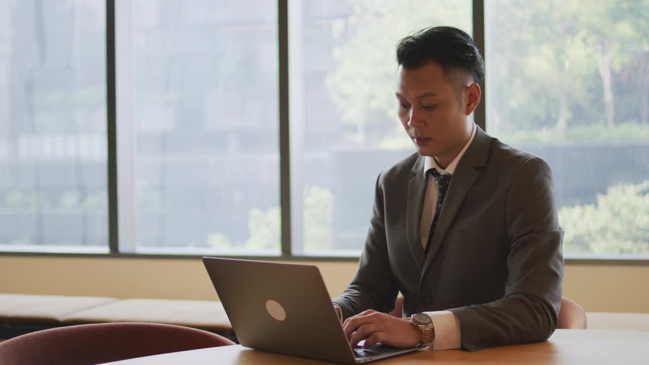 成功的亚洲商人使用笔记本电脑视频下载