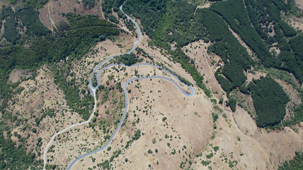 鸟瞰图，车辆行驶在弯弯曲曲的道路上，穿过夏季的山区景观视频下载