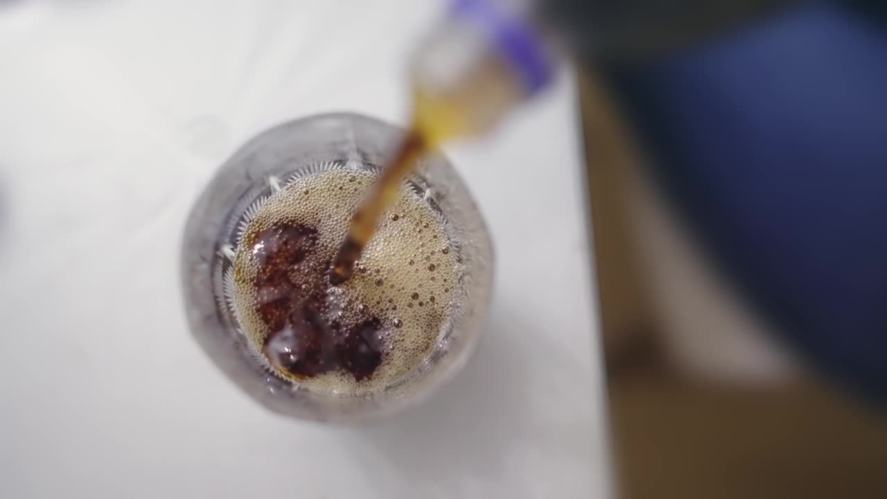 将软饮料可乐倒入玻璃杯，慢动作孤立的俯视图镜头视频下载