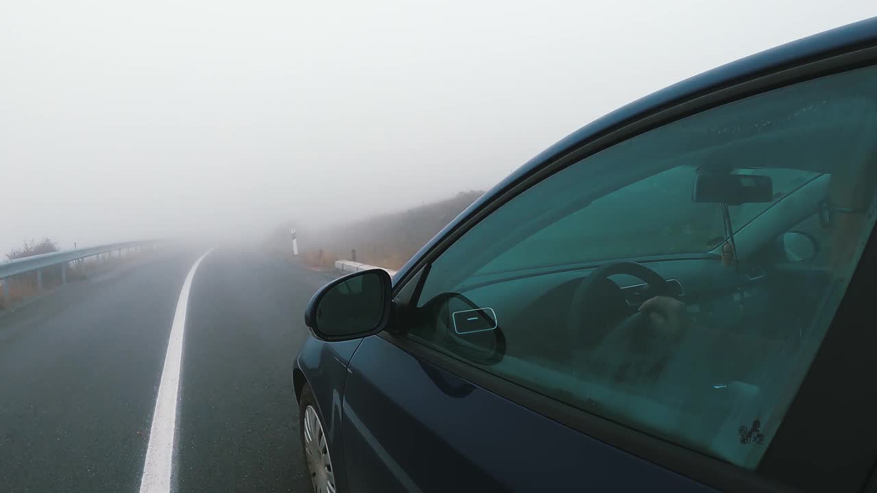 汽车在雾蒙蒙的森林中行驶，能见度低，道路湿滑视频下载