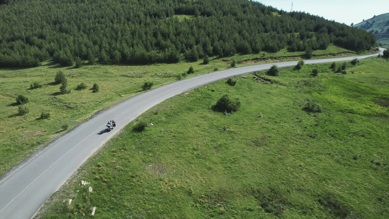 夏日里，骑摩托车的人在蓝天下的山路上骑摩托车，航拍画面视频下载