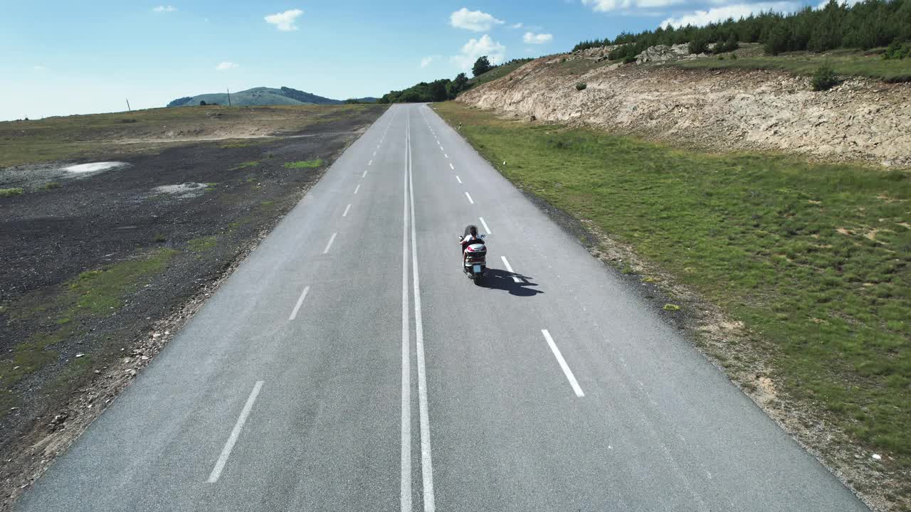 夏日里，骑摩托车的人在蓝天下的山路上骑摩托车，航拍画面视频下载