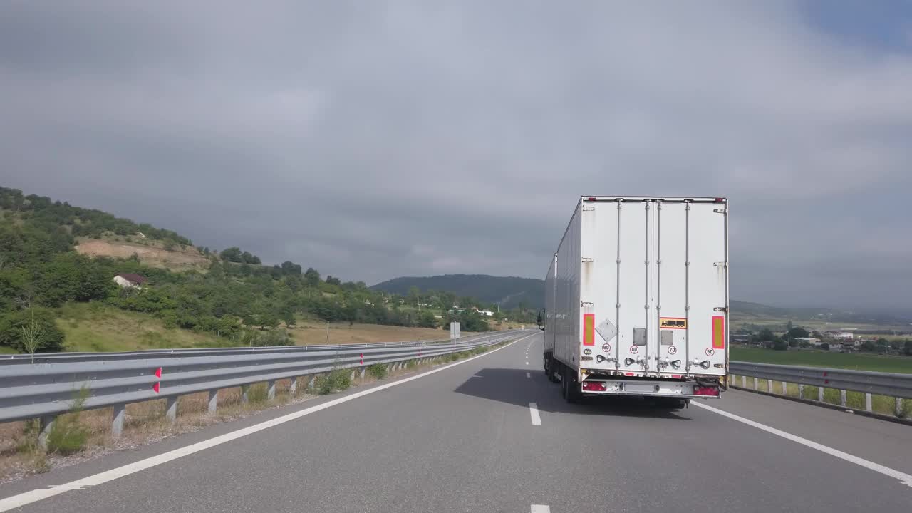 长长的白色卡车带着拖车在高速公路上运送货物，电影镜头视频下载