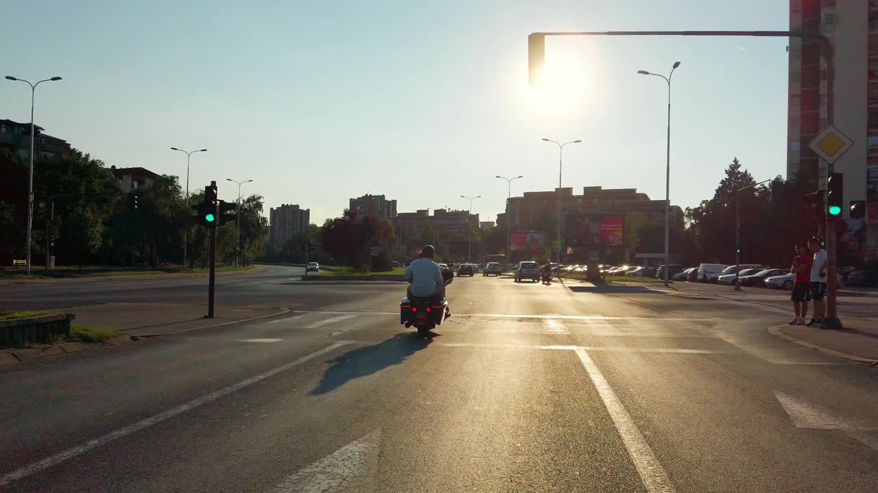 在日落和日出时，在城市大道上追踪一名骑着定制赛车摩托车的摩托车手视频下载