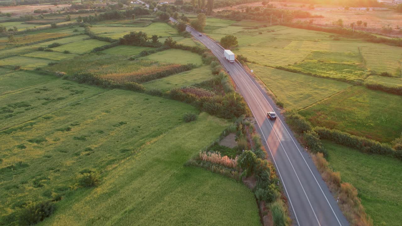 日落时分，卡车行驶在乡村公路上，电影般的航拍镜头视频下载
